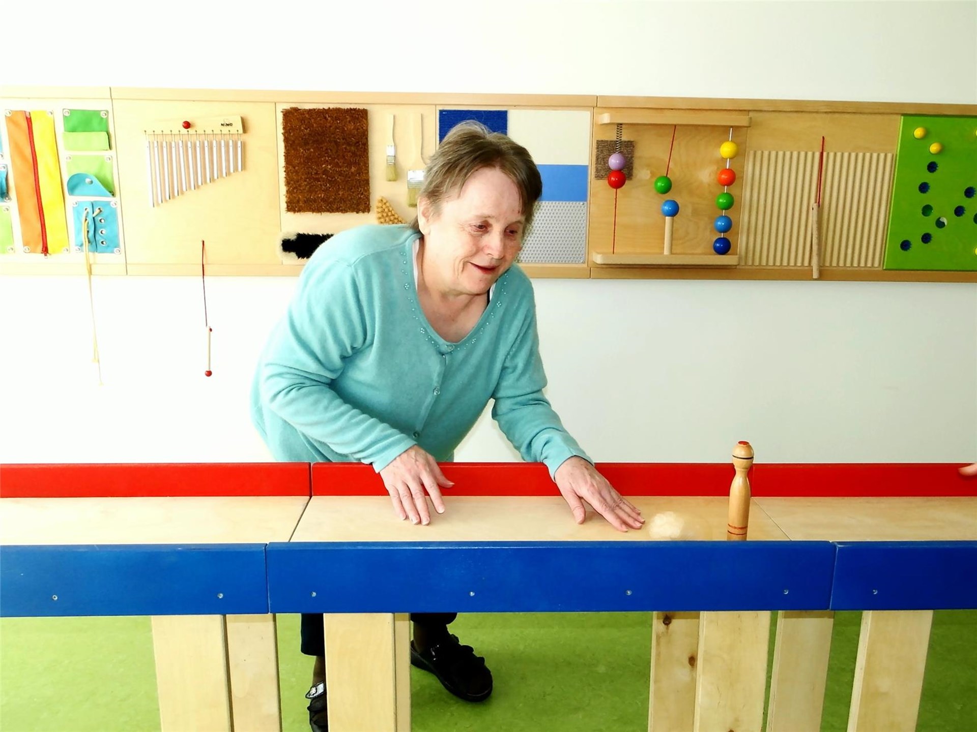 Eine Bewohnerin kegelt auf der Tischkegelbahn.
